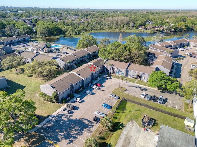 aerial view featuring a forest view, a water view, and a residential view