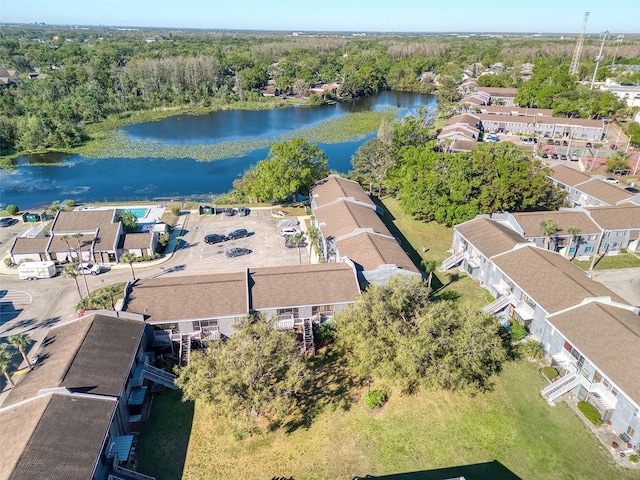 birds eye view of property featuring a forest view, a water view, and a residential view