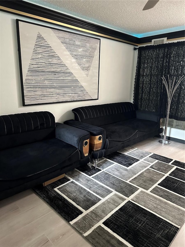 living area featuring visible vents, a textured ceiling, and wood finished floors