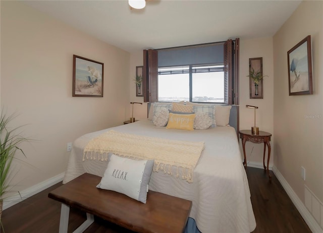 bedroom with baseboards and wood finished floors