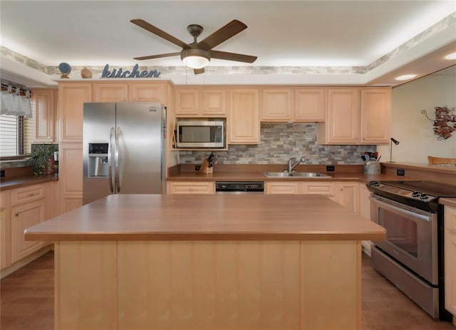 kitchen featuring a sink, a ceiling fan, light brown cabinetry, and stainless steel appliances