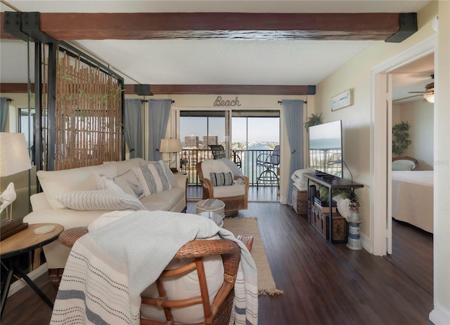 living area with a ceiling fan, beamed ceiling, wood finished floors, and baseboards