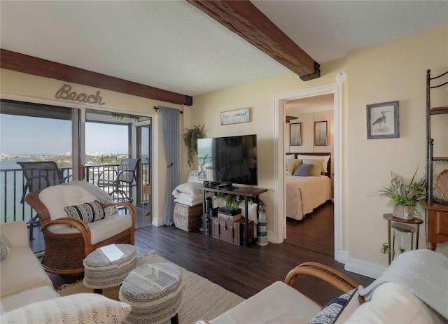 living area with beam ceiling, baseboards, and wood finished floors