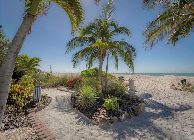 view of home's community with a water view and a beach view