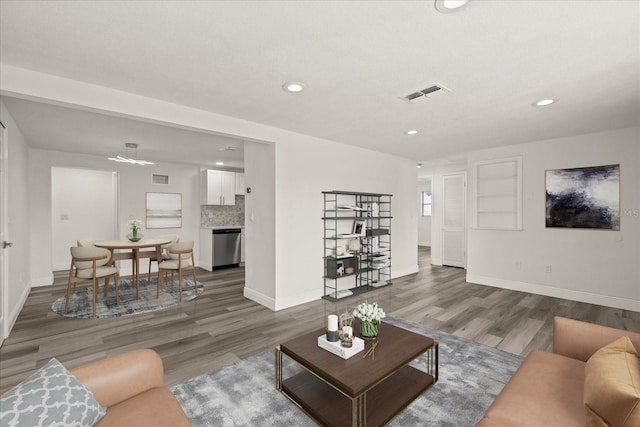 living room with visible vents, baseboards, and wood finished floors