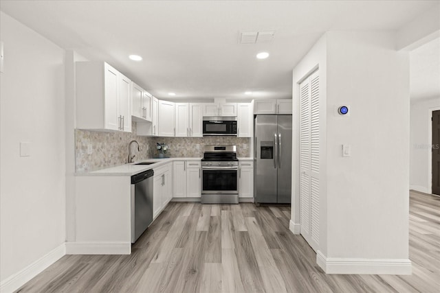 kitchen featuring a sink, light countertops, tasteful backsplash, and stainless steel appliances