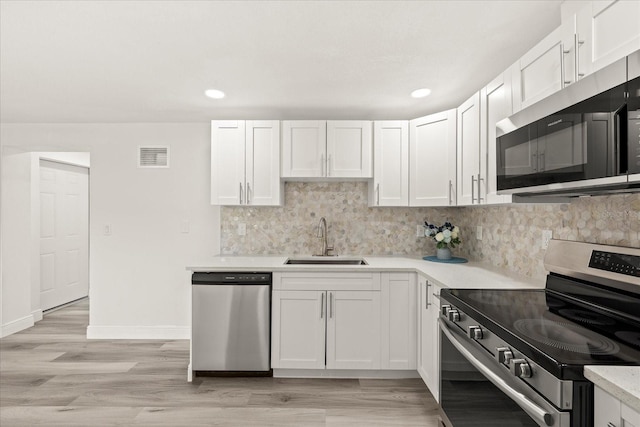 kitchen featuring visible vents, a sink, light countertops, appliances with stainless steel finishes, and backsplash