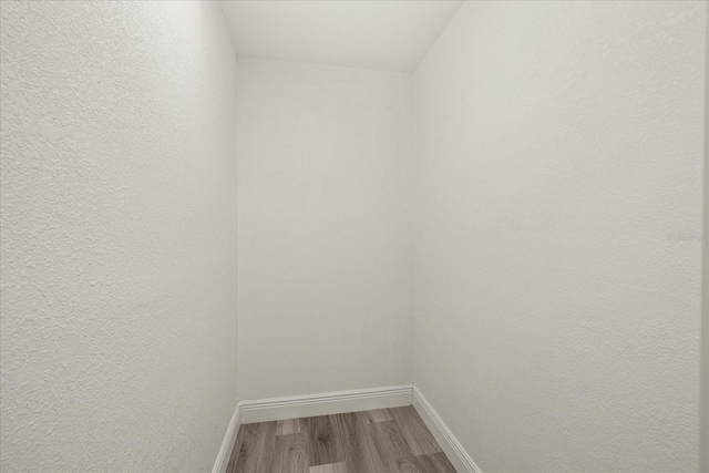 interior space with baseboards and wood finished floors