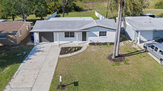 view of front of home featuring driveway, an attached garage, a front yard, and fence