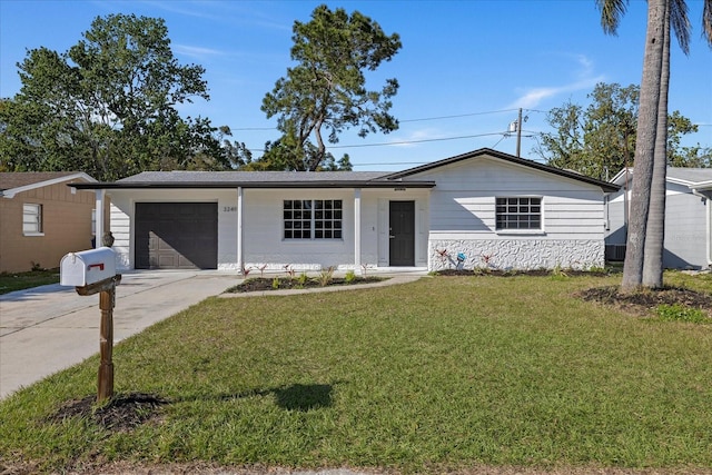 ranch-style house with concrete driveway, a garage, stone siding, and a front lawn