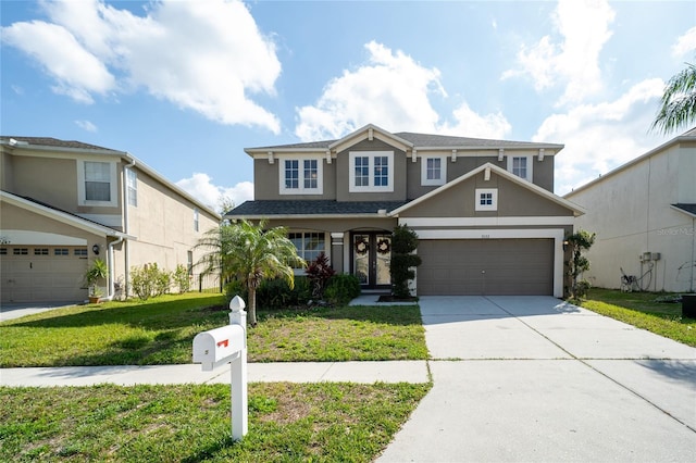 view of front of home with a front yard, an attached garage, driveway, and stucco siding