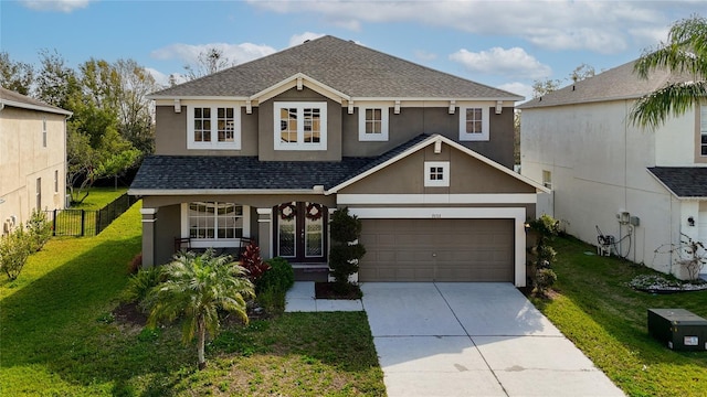 view of front facade featuring a front lawn, fence, concrete driveway, roof with shingles, and stucco siding