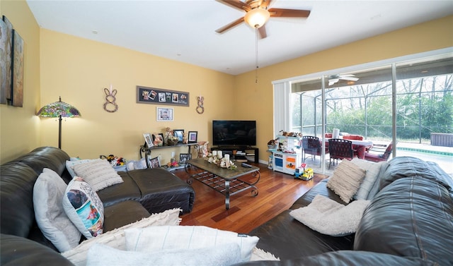 living area with wood finished floors and a ceiling fan