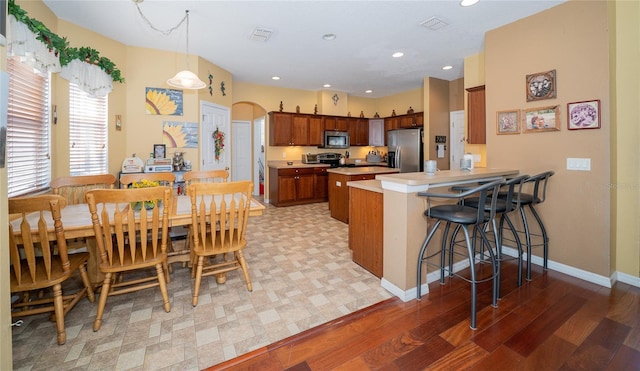 kitchen featuring visible vents, appliances with stainless steel finishes, a peninsula, and light countertops