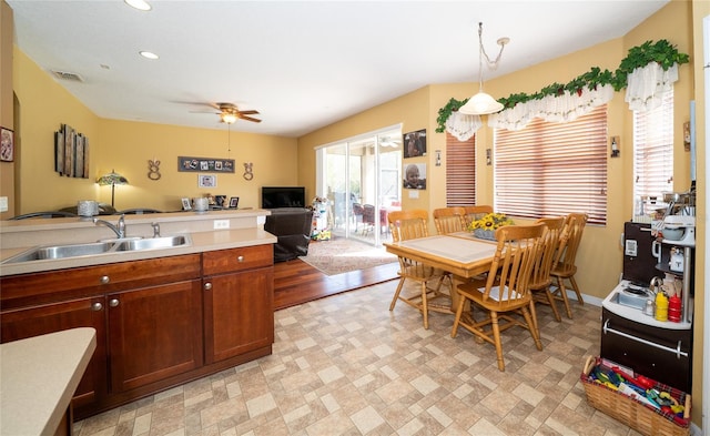 kitchen with visible vents, ceiling fan, a sink, light countertops, and open floor plan