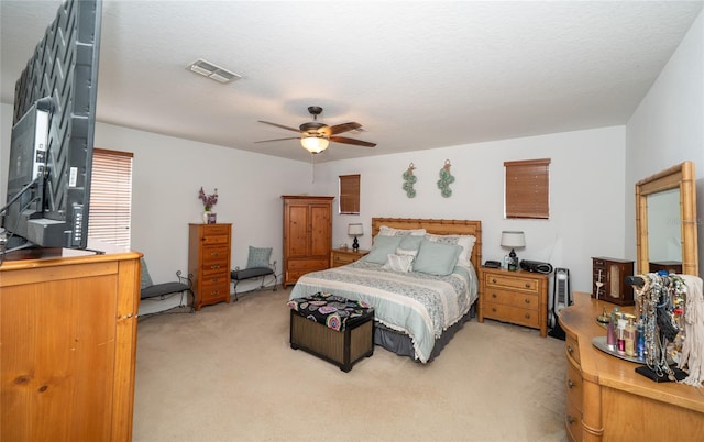 bedroom featuring light colored carpet, visible vents, and ceiling fan