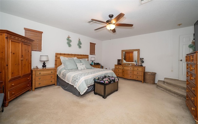 bedroom with visible vents, light carpet, and a ceiling fan