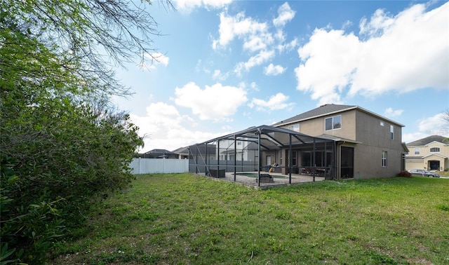 view of yard featuring a patio area, glass enclosure, a fenced in pool, and fence