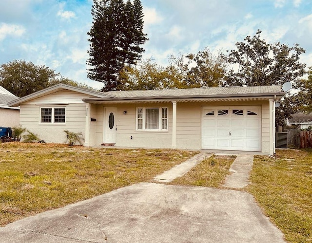 ranch-style home featuring concrete driveway, fence, a garage, and a front yard