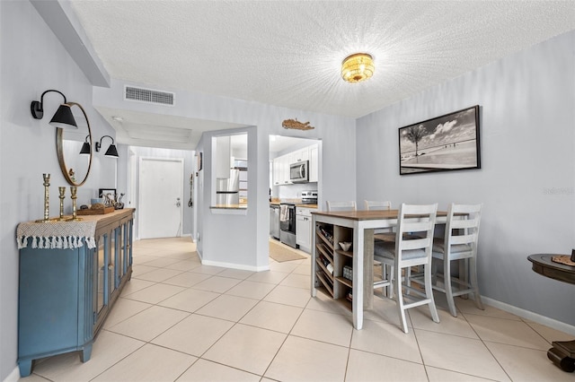 1986 Pelican Landing Blvd Unit 1514, Clearwater, FL 33762 - dining area featuring light tile patterned flooring, visible vents, a textured ceiling, and baseboards
