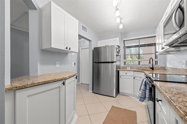 1986 Pelican Landing Blvd Unit 1514, Clearwater, FL 33762 - kitchen with light tile patterned floors, visible vents, a sink, stainless steel appliances, and white cabinetry