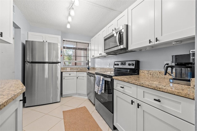 1986 Pelican Landing Blvd Unit 1514, Clearwater, FL 33762 - kitchen featuring white cabinetry, light tile patterned flooring, and stainless steel appliances