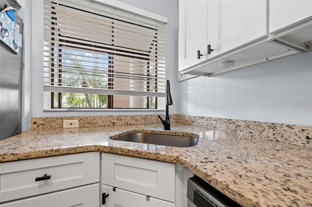 1986 Pelican Landing Blvd Unit 1514, Clearwater, FL 33762 - kitchen featuring white cabinets, light stone counters, and a sink