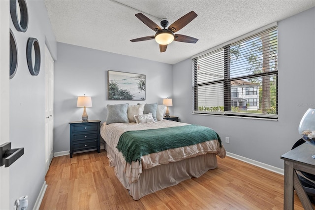 1986 Pelican Landing Blvd Unit 1514, Clearwater, FL 33762 - bedroom with baseboards, light wood-style floors, a ceiling fan, and a textured ceiling