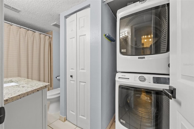 1986 Pelican Landing Blvd Unit 1514, Clearwater, FL 33762 - laundry room featuring stacked washer / drying machine, a textured ceiling, visible vents, and light tile patterned flooring