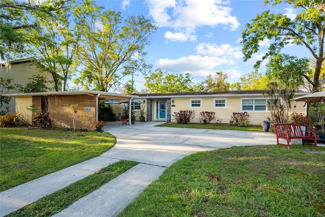 ranch-style house featuring a front yard, an attached carport, and driveway