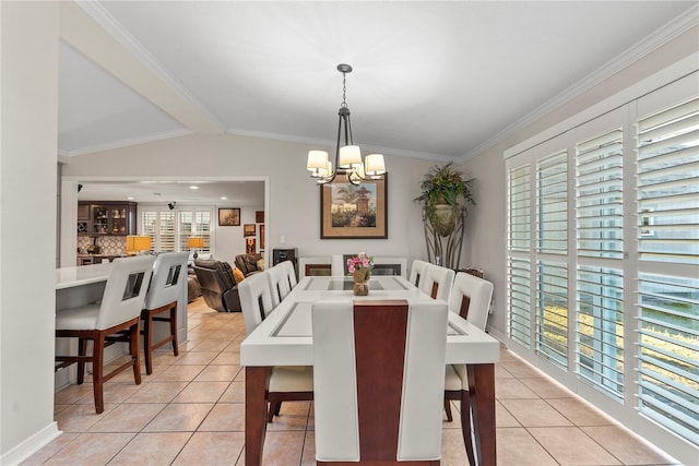 dining space with light tile patterned floors, crown molding, an inviting chandelier, and vaulted ceiling