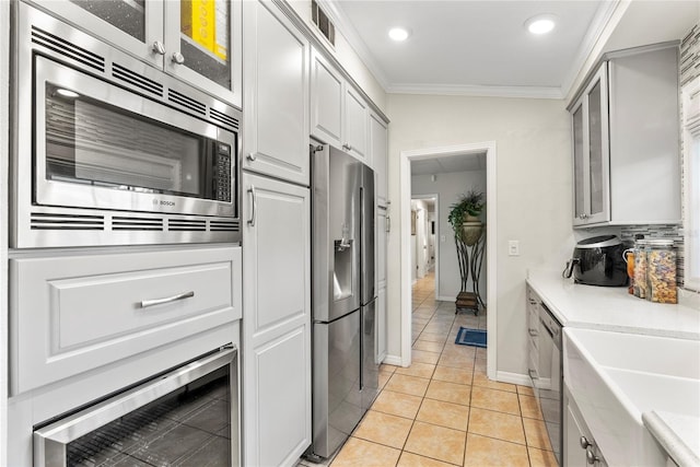 kitchen featuring visible vents, light countertops, ornamental molding, light tile patterned flooring, and stainless steel appliances