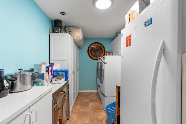 washroom with washer and dryer, baseboards, and cabinet space