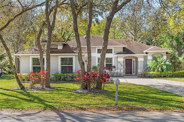 mediterranean / spanish house with stucco siding and a front yard