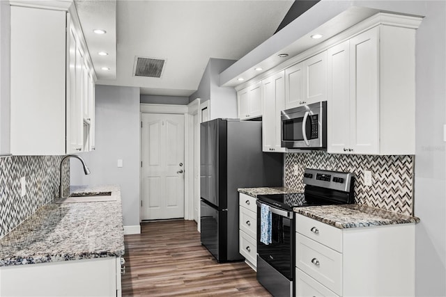 kitchen with white cabinets, visible vents, appliances with stainless steel finishes, and a sink