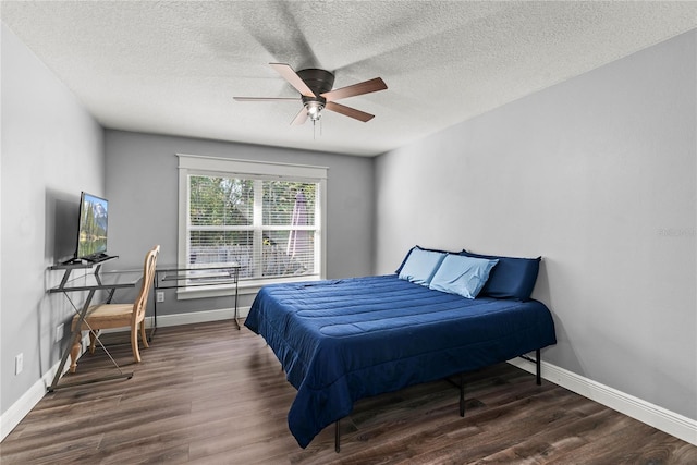 bedroom featuring ceiling fan, a textured ceiling, baseboards, and wood finished floors