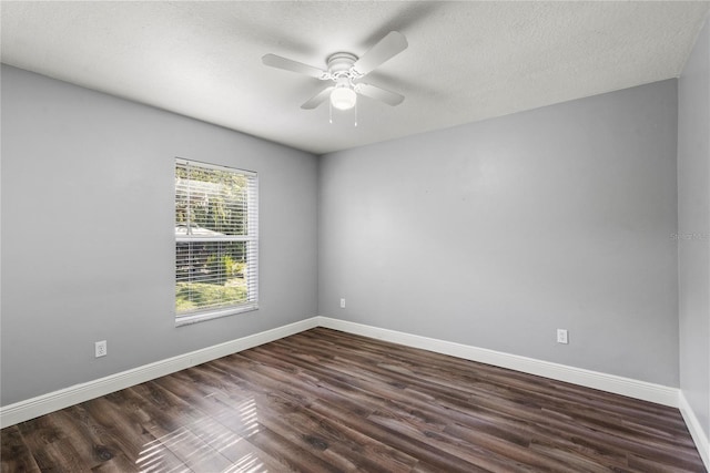 spare room with baseboards, a textured ceiling, dark wood-style flooring, and a ceiling fan