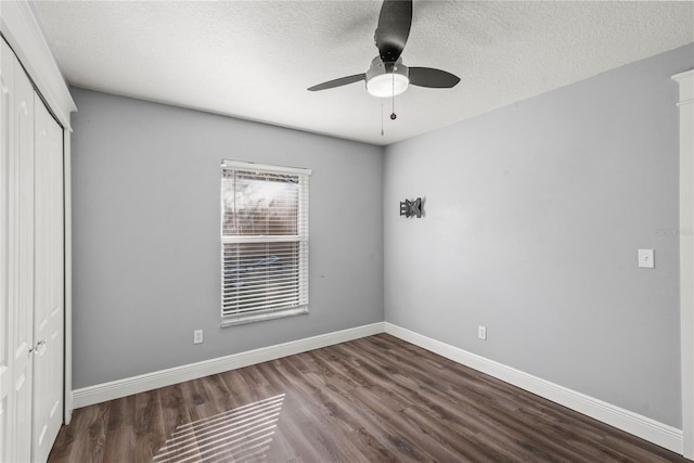 unfurnished bedroom featuring a ceiling fan, a textured ceiling, wood finished floors, a closet, and baseboards