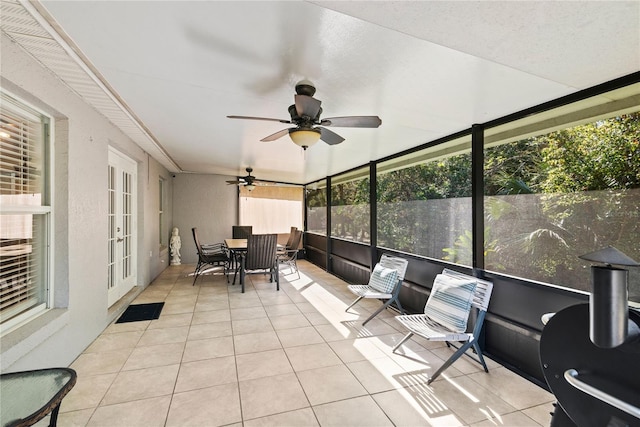 sunroom / solarium featuring a ceiling fan and french doors