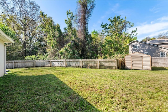 view of yard featuring a fenced backyard, a storage unit, and an outdoor structure