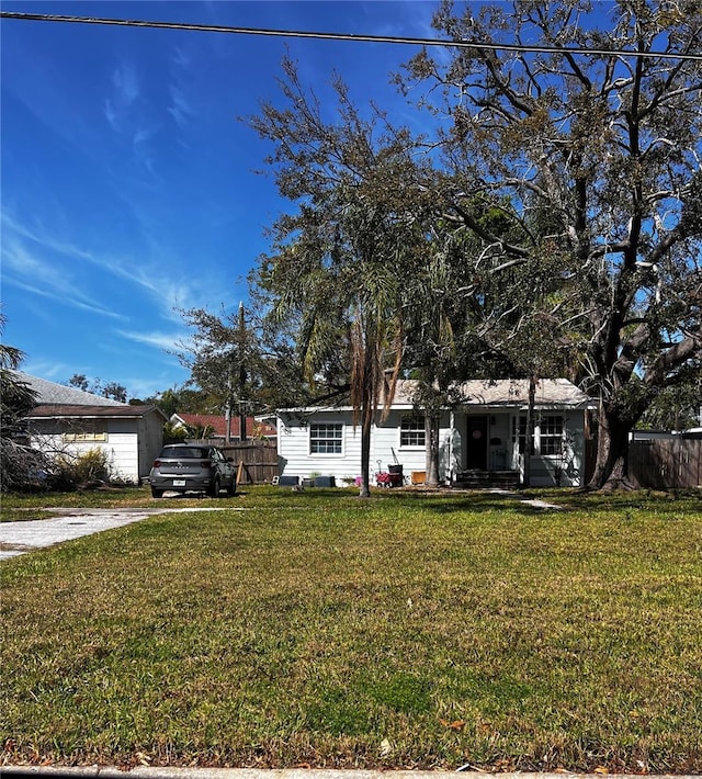 ranch-style house with covered porch, a front lawn, and fence