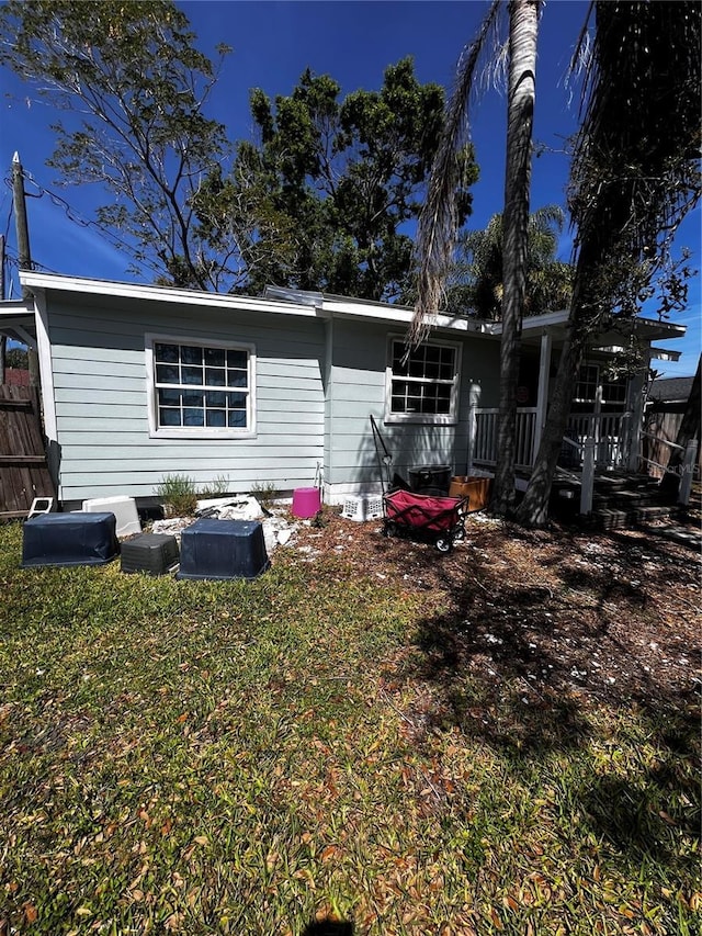 back of house featuring fence and a lawn