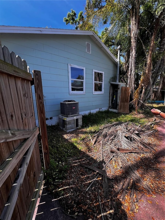 view of home's exterior with central AC unit and fence