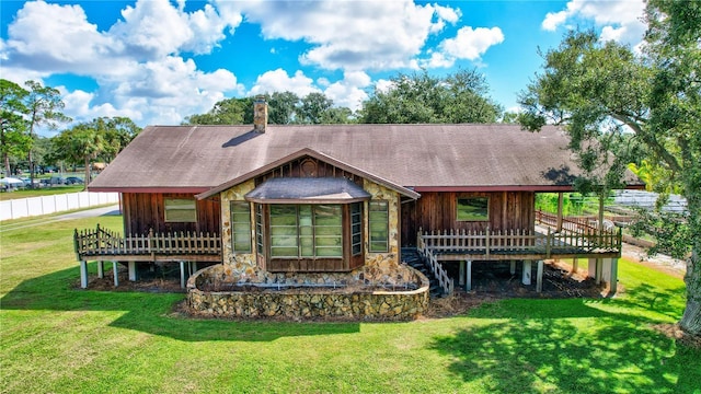 6501 62nd St N, Pinellas Park, FL 33781 - back of house featuring a lawn, a wooden deck, stone siding, and roof with shingles