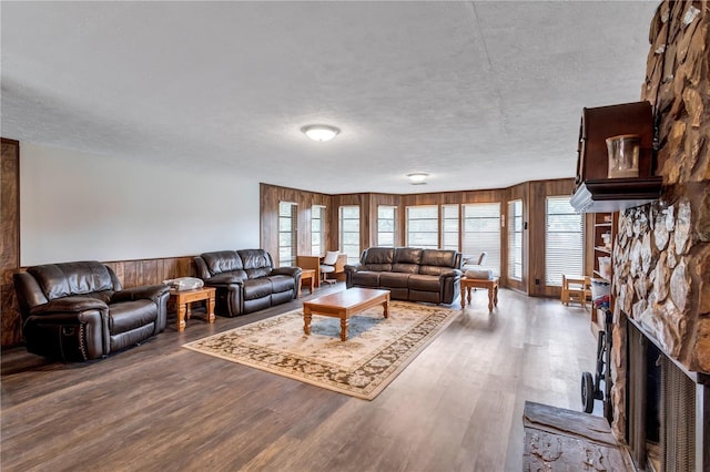 6501 62nd St N, Pinellas Park, FL 33781 - living area with a textured ceiling, wood finished floors, wooden walls, and a stone fireplace