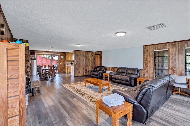 6501 62nd St N, Pinellas Park, FL 33781 - living area featuring visible vents, wood walls, a textured ceiling, and wood finished floors