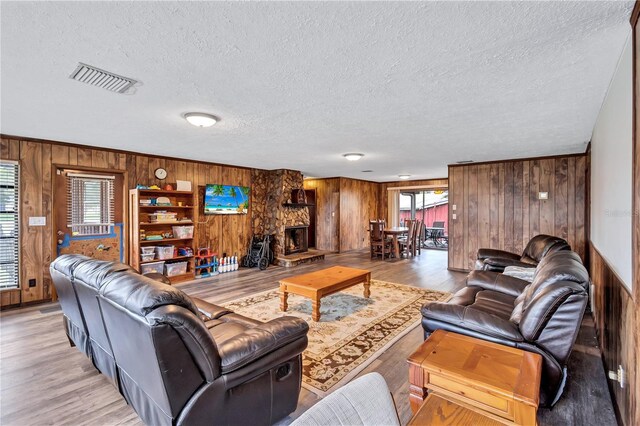 6501 62nd St N, Pinellas Park, FL 33781 - living area featuring a textured ceiling, visible vents, wooden walls, and light wood-type flooring