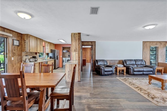 6501 62nd St N, Pinellas Park, FL 33781 - dining room with separate washer and dryer, wood walls, light wood-type flooring, visible vents, and a healthy amount of sunlight