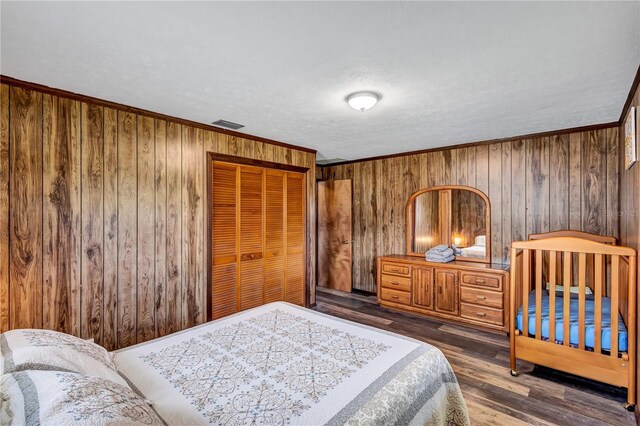 6501 62nd St N, Pinellas Park, FL 33781 - bedroom featuring a closet, visible vents, wooden walls, ornamental molding, and wood finished floors