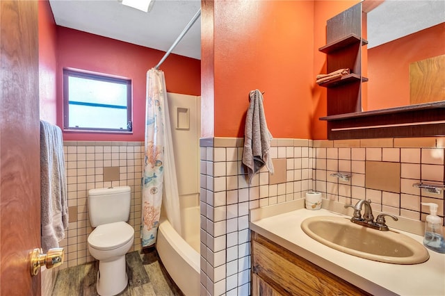 6501 62nd St N, Pinellas Park, FL 33781 - full bathroom featuring vanity, tile walls, toilet, a wainscoted wall, and shower / bath combination with curtain